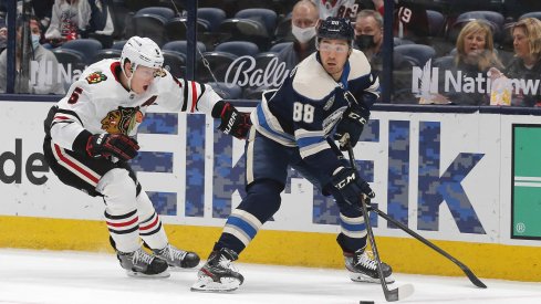 Apr 12, 2021; Columbus, Ohio, USA; Columbus Blue Jackets right wing Kole Sherwood (88) picks up a loose puck as Chicago Blackhawks defenseman Connor Murphy (5) defends during the first period at Nationwide Arena.