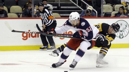 Sep 27, 2021; Pittsburgh, Pennsylvania, USA; Columbus Blue Jackets center Emil Bemstrom (52) skates with the puck around Pittsburgh Penguins defenseman Chad Ruhwedel (2) during the second period at PPG Paints Arena.