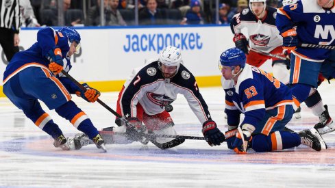 New York Islanders' Sebastian Aho and Casey Cizikas battle for the loose puck with Columbus Blue Jackets' Sean Kuraly in the first period at UBS Arena.