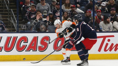 Philadelphia Flyers' Cam Atkinson shoots the puck over Columbus Blue Jackets' Zach Werenski at Nationwide Arena.