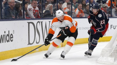 Philadelphia Flyers' Cam Atkinson plays the puck against Columbus Blue Jackets' Jake Bean during the third period at Nationwide Arena.