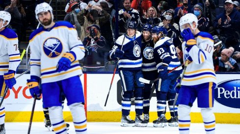 Columbus Blue Jackets center Boone Jenner celebrates with teammates left wing Patrik Laine and right wing Jakub Voracek after scoring a goal against the Buffalo Sabres.