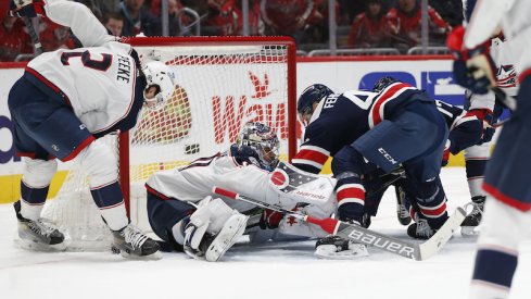 Columbus Blue Jackets' Elvis Merzlikins and Blue Jackets' Andrew Peeke make a save against Washington Capitals defenseman Martin Fehervary during the first period at Capital One Arena.