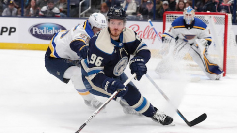 Columbus Blue Jackets center Jack Roslovic (96) skates the puck away from the check of St. Louis Blues defenseman Colton Parayko (55) during the first period at Nationwide Arena.