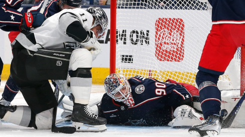 Columbus Blue Jackets goalie Elvis Merzlikins (90) covers a loose puck as Los Angeles Kings center Anze Kopitar (11) looks for the rebound during the second period at Nationwide Arena.