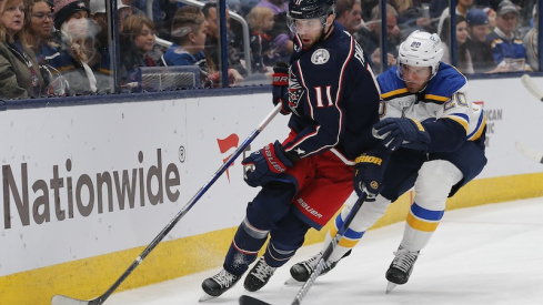 Columbus Blue Jackets' Adam Fantilli picks up a loose puck as St. Louis Blues' Brandon Saad trails the play during the first period at Nationwide Arena.