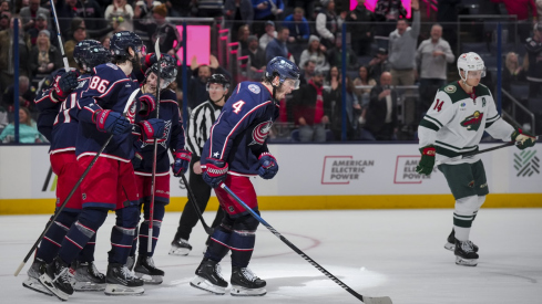 Cole Sillinger celebrates with teammates after scoring a hat-trick goal against the Minnesota Wild