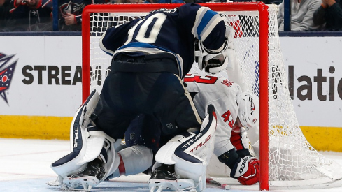 Columbus Blue Jackets goalie Elvis Merzlikins (90) and Washington Capitals right wing Tom Wilson (43) tangle inside the net during overtime at Nationwide Arena.