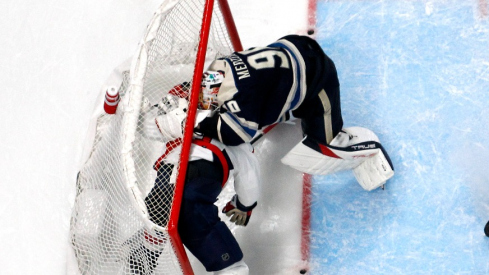 Washington Capitals right wing Tom Wilson (43) and Columbus Blue Jackets goalie Elvis Merzlikins (90) battle inside the goals during overtime at Nationwide Arena.