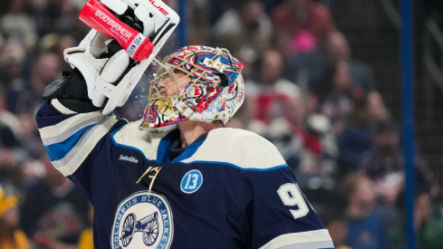 Columbus Blue Jackets goaltender Elvis Merzlikins (90) sprays his face with water during a stop in play against the New York Islanders in the first period at Nationwide Arena.