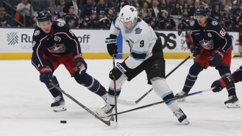 Columbus Blue Jackets defenseman Zach Werenski (8) steals the puck from Utah Hockey Club center Clayton Keller (9) during the first period at Nationwide Arena.