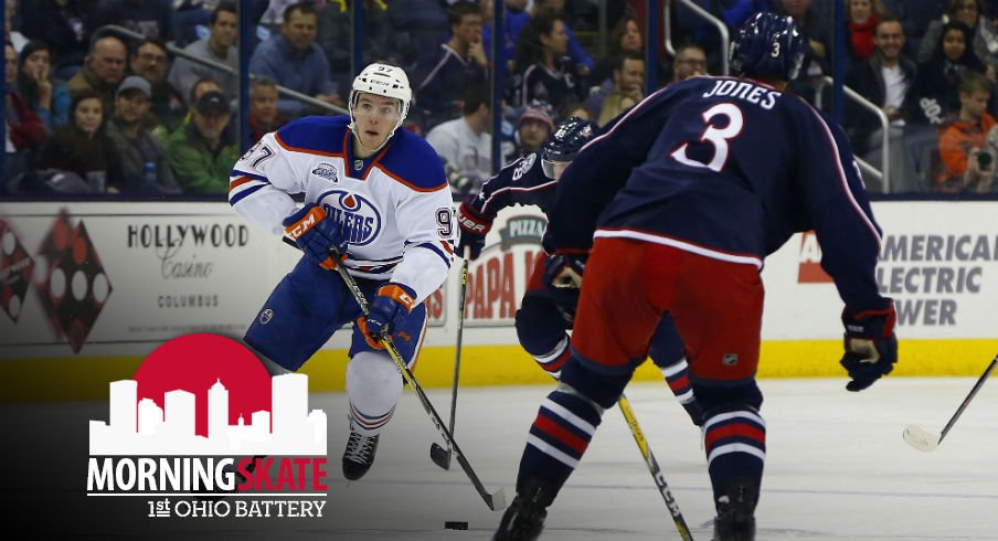 Connor McDavid skates the puck up the ice against Seth Jones