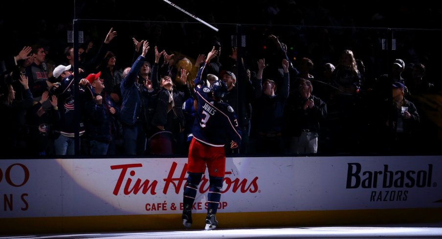 Seth Jones gives away a stick after being named a star after the game