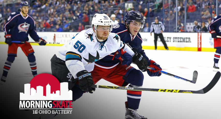 Zach Werenski tries to fight Sharks Chris Tierney off of the puck