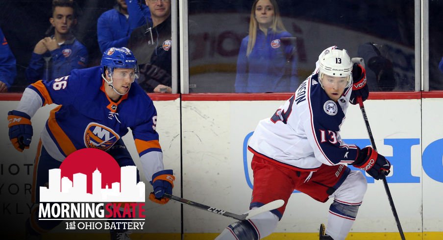 Cam Atkinson attempts to skate away from an Islanders defenseman