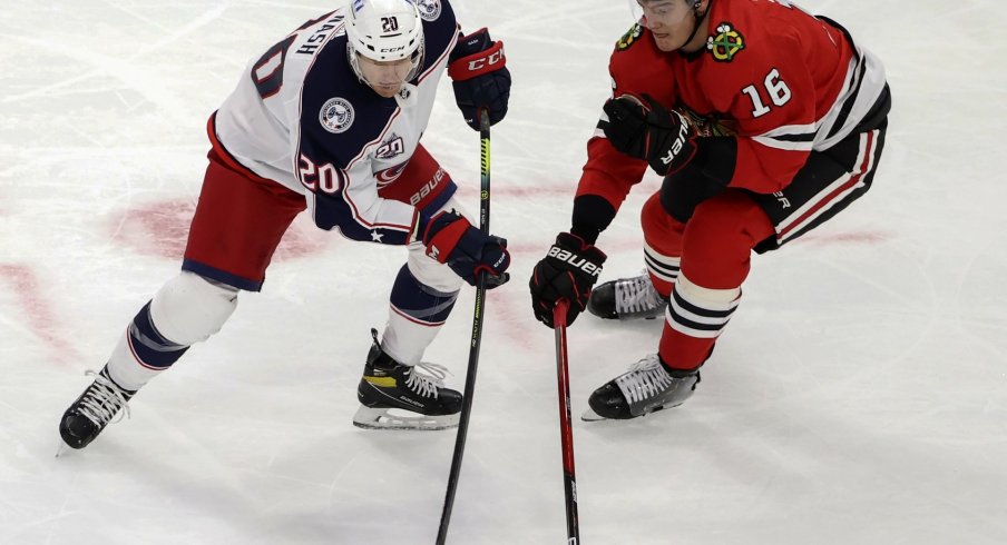 Chicago Blackhawks defenseman Nikita Zadorov battles for the puck against Columbus Blue Jackets center Riley Nash.