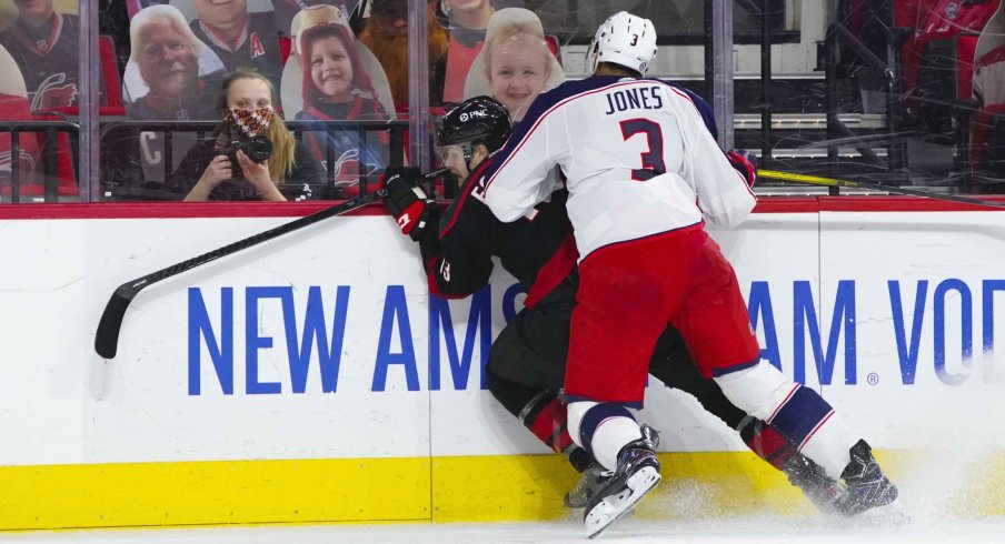 Mar 18, 2021; Raleigh, North Carolina, USA; Columbus Blue Jackets defenseman Seth Jones (3) checks Carolina Hurricanes left wing Warren Foegele (13) during the second period at PNC Arena.