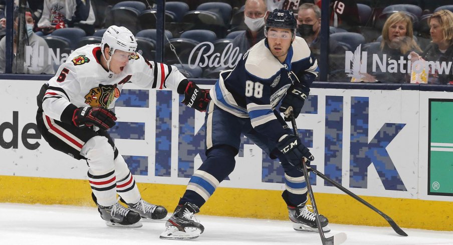 Apr 12, 2021; Columbus, Ohio, USA; Columbus Blue Jackets right wing Kole Sherwood (88) picks up a loose puck as Chicago Blackhawks defenseman Connor Murphy (5) defends during the first period at Nationwide Arena.