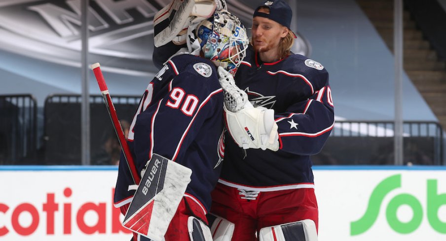 Columbus Blue Jackets' goaltenders Joonas Korpisalo and Elvis Merzlikins embrace following an exhibition game against the Boston Bruins at Scotiabank Arena.