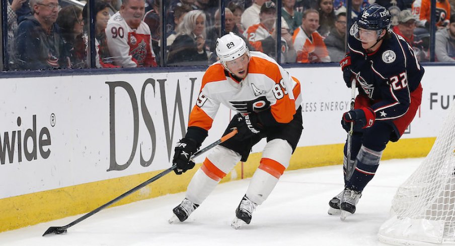 Philadelphia Flyers' Cam Atkinson plays the puck against Columbus Blue Jackets' Jake Bean during the third period at Nationwide Arena.