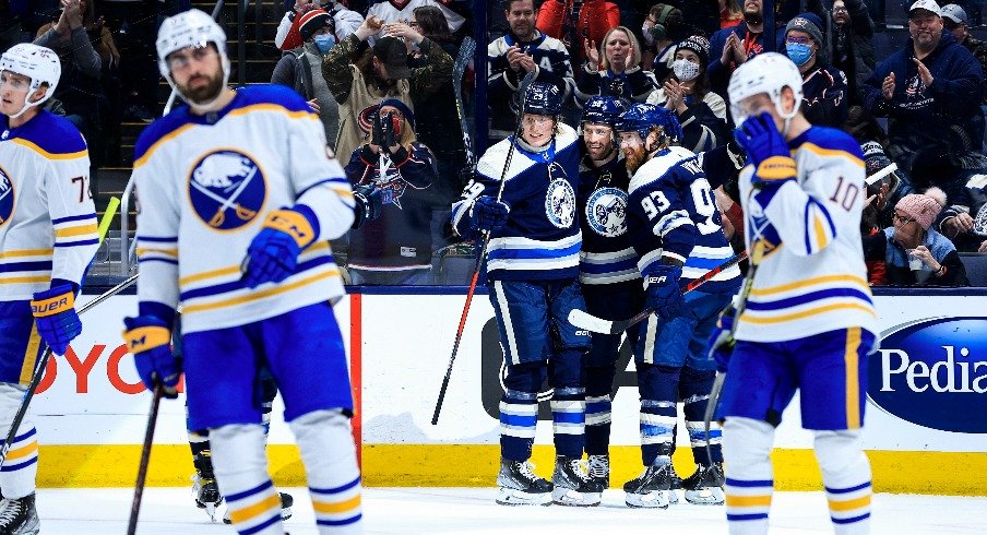 Columbus Blue Jackets center Boone Jenner celebrates with teammates left wing Patrik Laine and right wing Jakub Voracek after scoring a goal against the Buffalo Sabres.