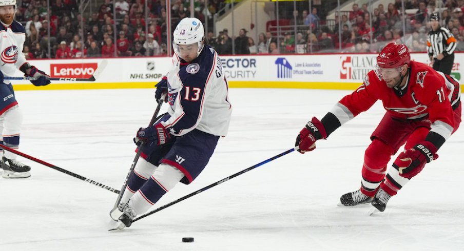 Columbus Blue Jackets' Johnny Gaudreau skates with the puck past Carolina Hurricanes' Jordan Staal during the second period at PNC Arena.