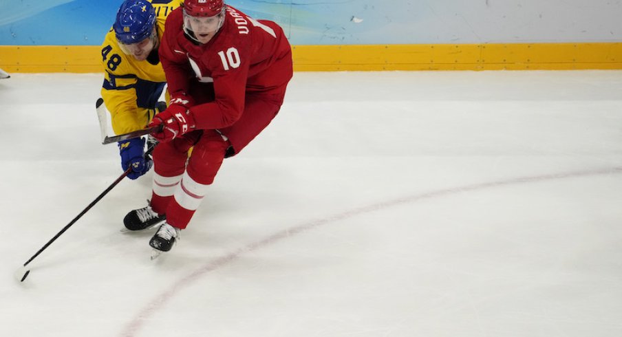 Team ROC forward Dmitri Voronkov and Team Sweden forward Carl Klingberg battle for the puck in the third period during the Beijing 2022 Olympic Winter Games at National Indoor Stadium.