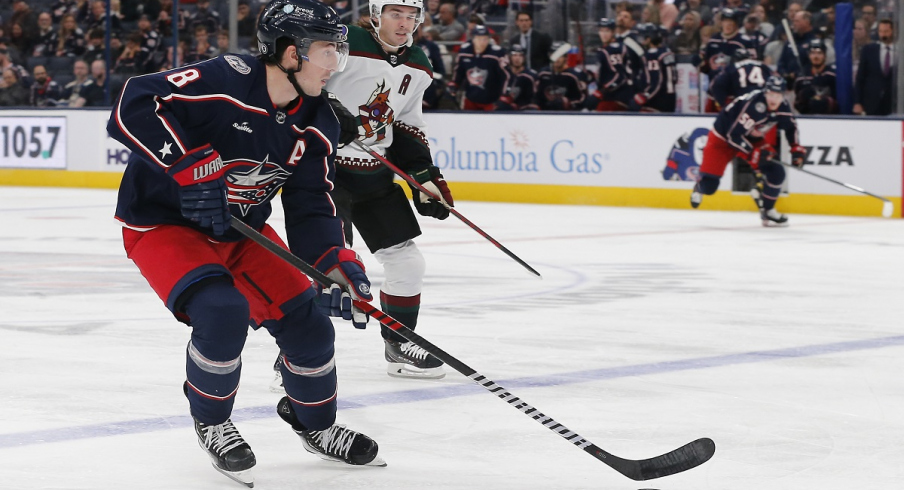 Zach Werenski skates with the puck against the Arizona Coyotes