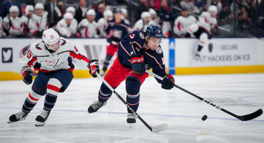 Columbus Blue Jackets defenseman Denton Mateychuk (5) passes the puck against Washington Capitals forward Matthew Phillips (45) in the first period at Nationwide Arena.