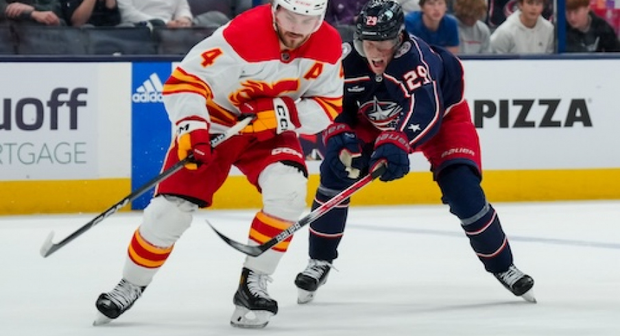 Calgary Flames defenseman Rasmus Andersson (4) skates with the puck against Columbus Blue Jackets right wing Patrik Laine (29) in the third period at Nationwide Arena.