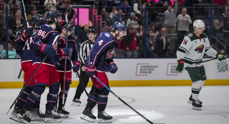 Cole Sillinger celebrates with teammates after scoring a hat-trick goal against the Minnesota Wild