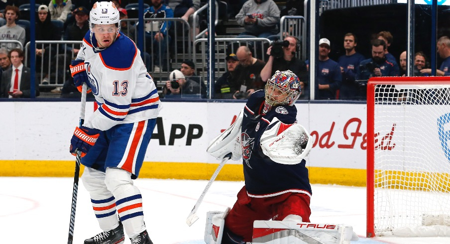 Columbus Blue Jackets goalie Elvis Merzlikins (90) makes a glove save as Edmonton Oilers center Mattias Janmark (13) looks for a rebound during the third period at Nationwide Arena.