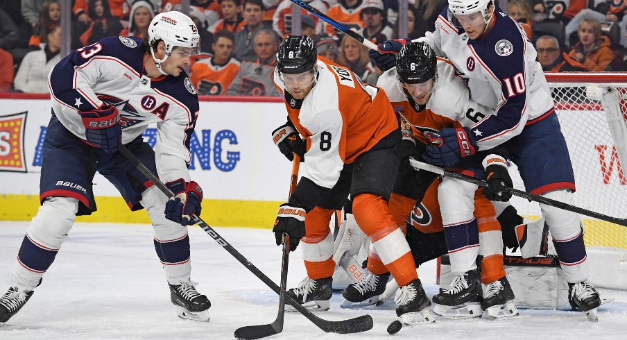 Columbus Blue Jackets center Sean Monahan (23) battles for the puck against Philadelphia Flyers defenseman Cam York (8) during the first period at Wells Fargo Center.