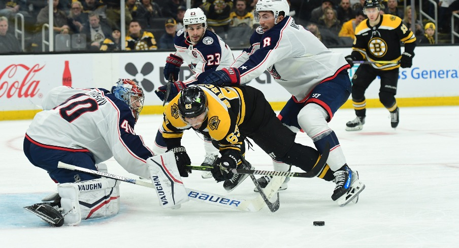 Columbus Blue Jackets defenseman Zach Werenski (8) is called for a penalty on Boston Bruins left wing Brad Marchand (63) during the third period at TD Garden.