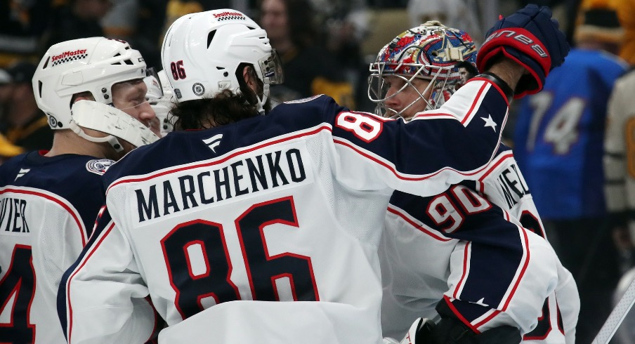 Columbus Blue Jackets right wing Kirill Marchenko (86) and goaltender Elvis Merzlikins (90) celebrate after Marchenko scored the game-winning goal in a shootout against the Pittsburgh Penguins at PPG Paints Arena.