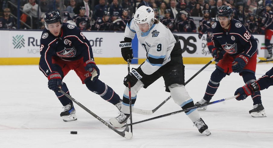 Columbus Blue Jackets defenseman Zach Werenski (8) steals the puck from Utah Hockey Club center Clayton Keller (9) during the first period at Nationwide Arena.